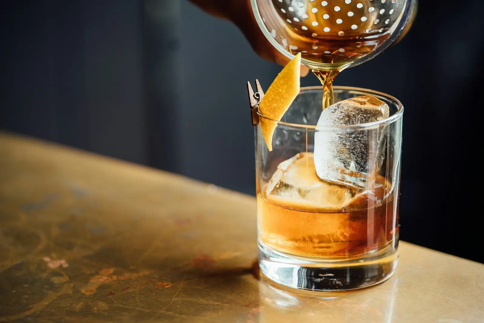 A whisky cocktail poured over ice with orange peel