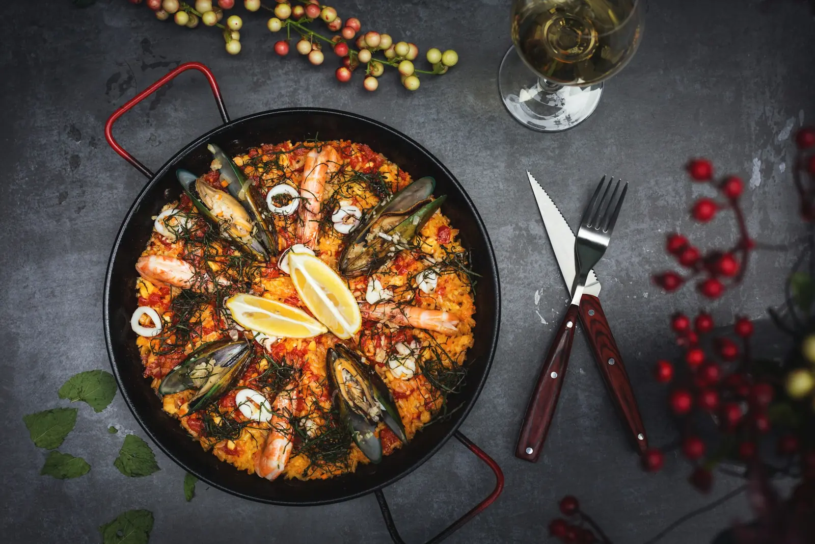 A pan of seafood paella with lemon and herbs