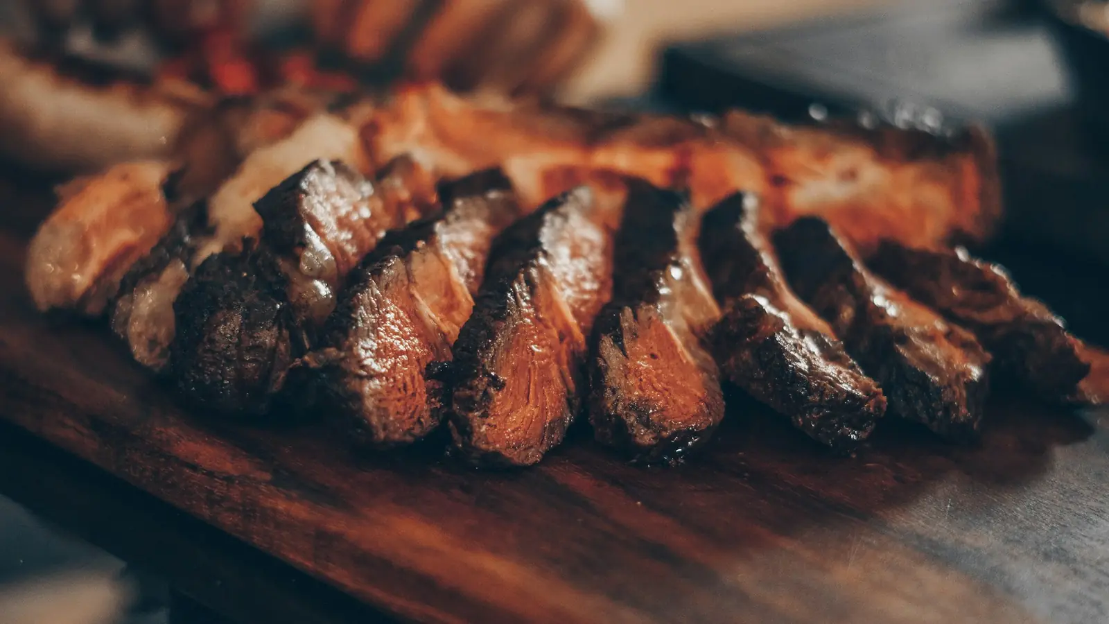 Sliced seared beef on a wooden board