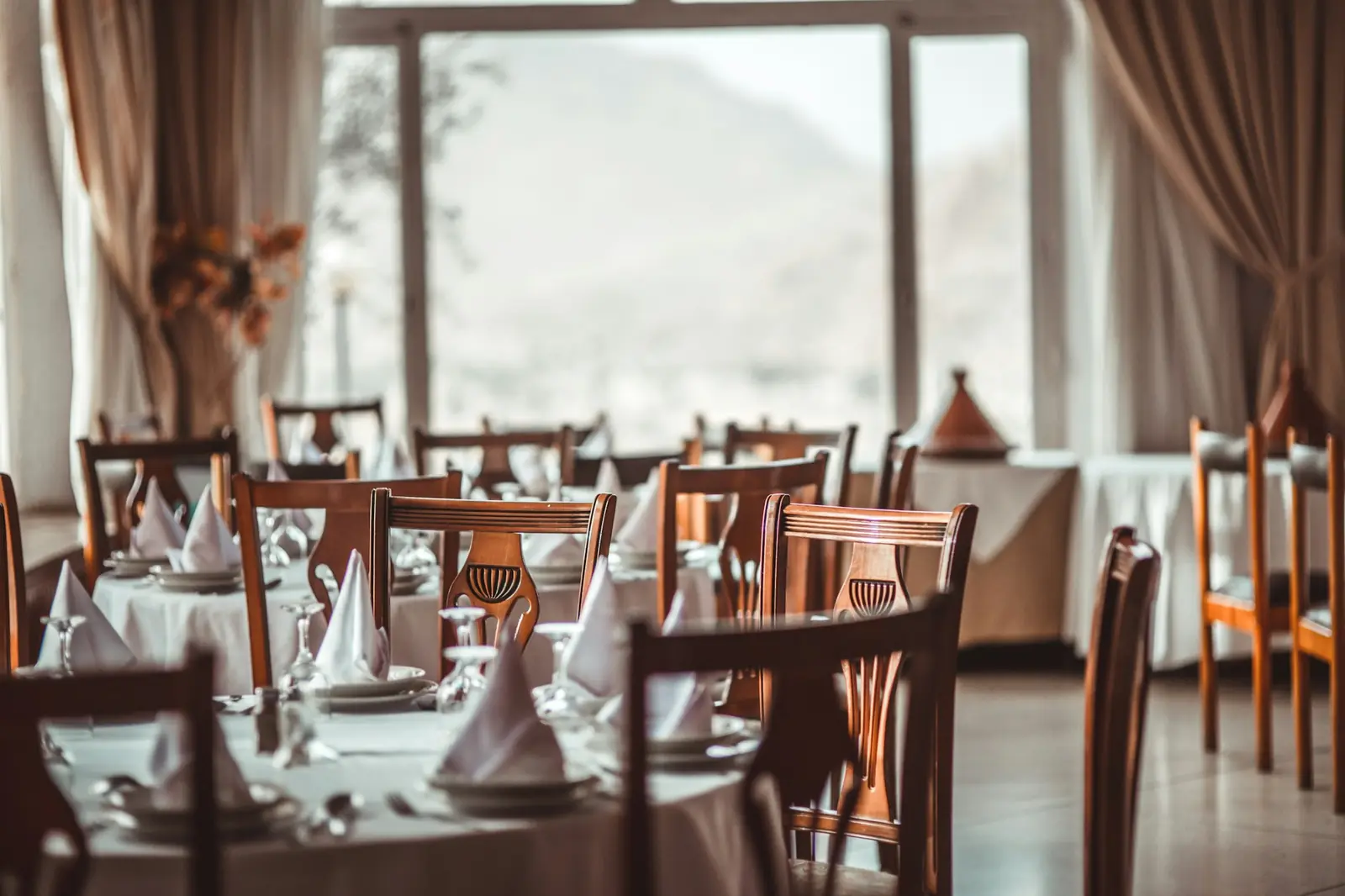 A quiet, elegantly laid dining room by a large window