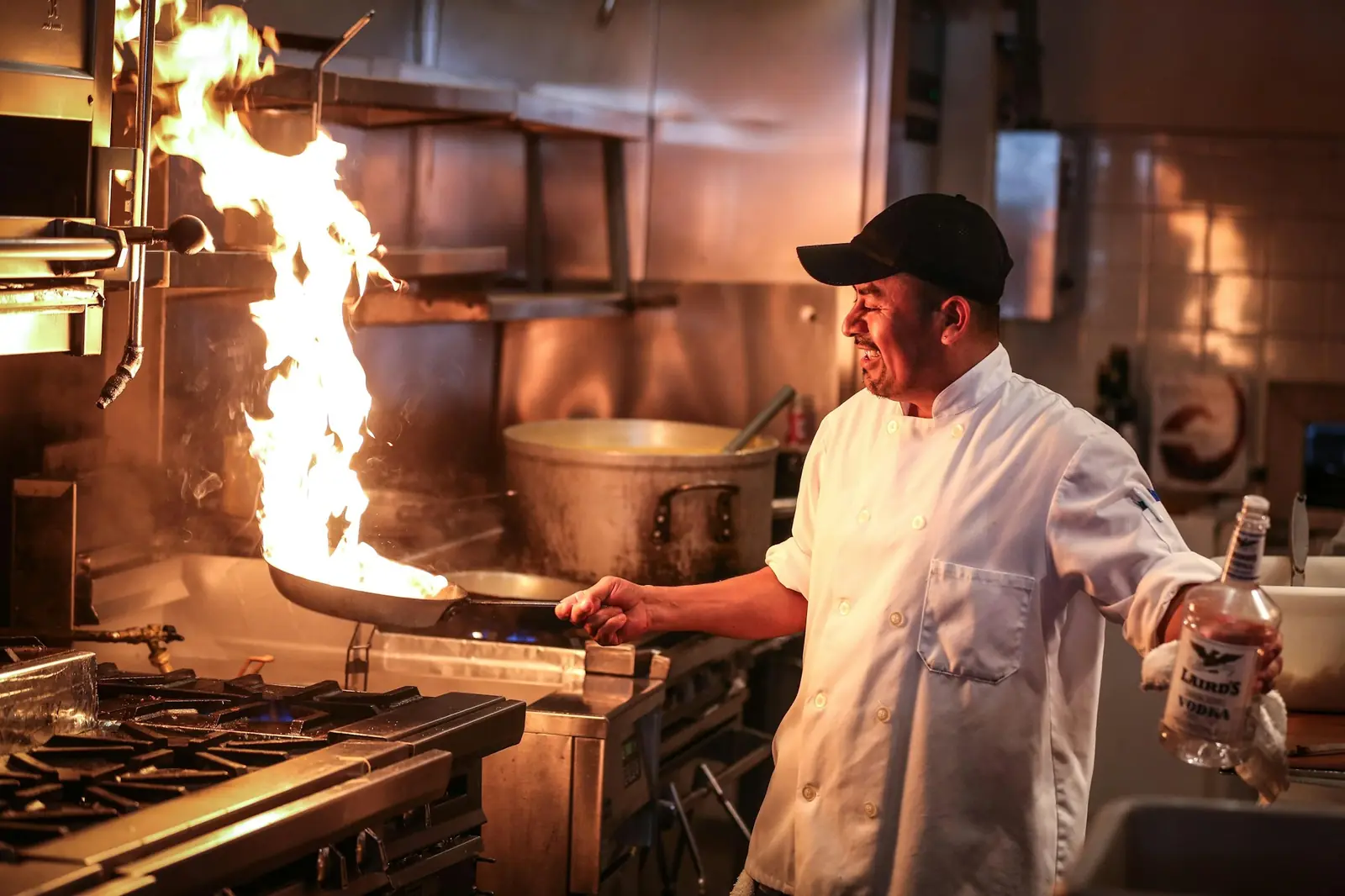 A chef working over open flame in the kitchen